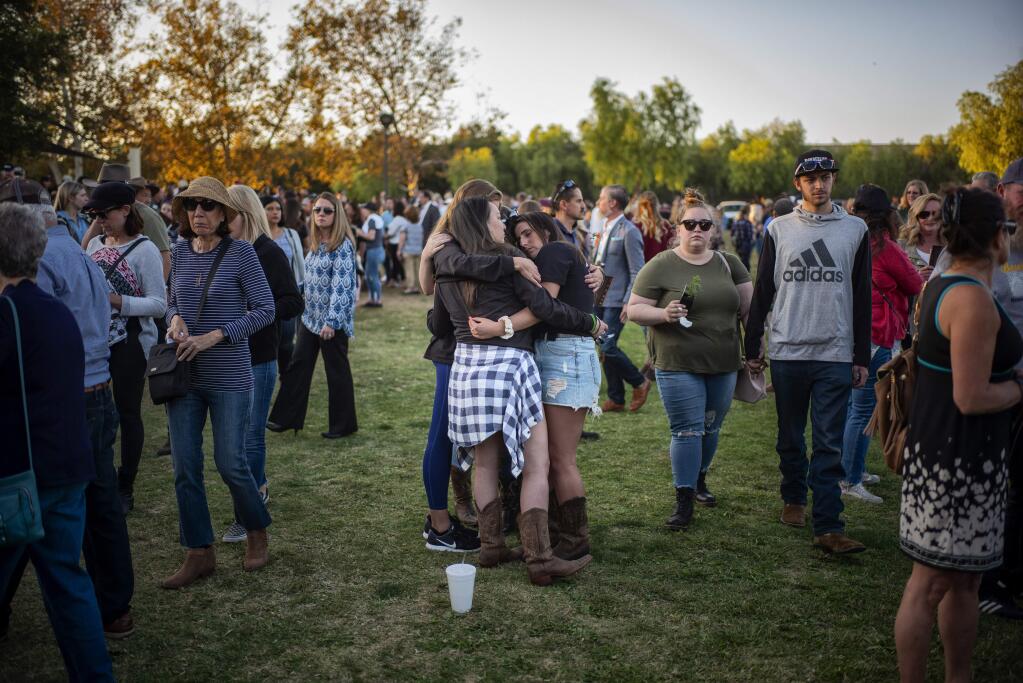 People comfort one another during the dedication of the Borderline Healing Garden at Conejo Creek Park in Thousand Oaks, Calif., Thursday, Nov. 7, 2019. The dedication marked the anniversary of a fatal mass shooting at a country-western bar a year earlier. (Hans Gutknecht/The Orange County Register via AP)