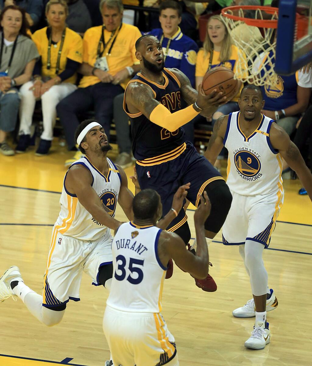 LeBron James threads the lane for two, through James Michael McAdoo, left, Kevin Durant and Andre Iguodala during Game 1 of the NBA Finals against Cleveland, Thursday June 1, 2017 in Oakland. (Kent Porter / The Press Democrat)