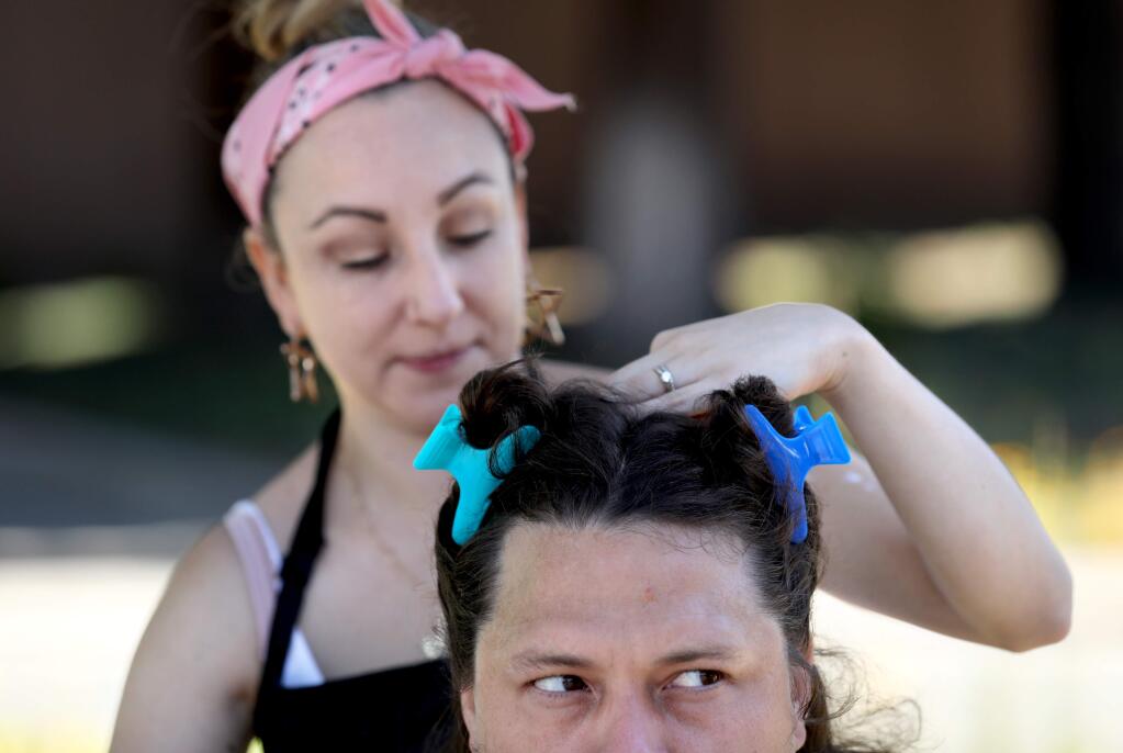 Marion Joshua White gets a haircut from Dhel Camp, a student at Lytle's Beauty College, during a free haircuts for the homeless event at Santa Rosa City Hall in Santa Rosa on Sunday, July 21, 2019. (BETH SCHLANKER/ The Press Democrat)