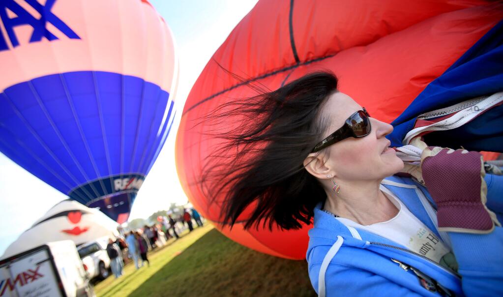 Diane Inman of Petaluma volunteers her time to tether a hot air balloon during the 25th anniversary of the Sonoma County Hot Air Balloon Classic in Windsor, Saturday June 20, 2015. (Kent Porter / Press Democrat) 2015