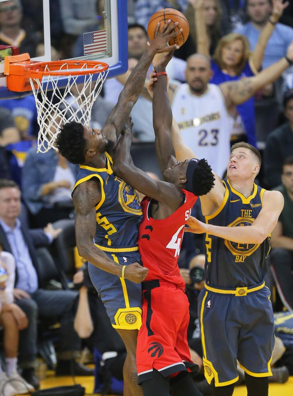 Warriors forward Jordan Bell, left, blocks a shot attempt by Raptors forward Pascal Siakam, while Warriors forward Jonas Jerebko helps on defense, during their game in Oakland on Wednesday, December 12, 2018. (Christopher Chung/ The Press Democrat)