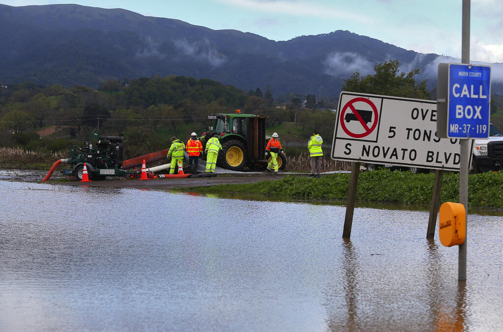 Caltrans personnel work on a pump, in an effort to alleviate the flooding at Highway 37, east of the Hannah Ranch Road offramp, in Novato, on Monday, January 23, 2017.  Flood waters forced the closure of all lanes in both directions on Highway 37, between Atherton Avenue and Highway 101.(Christopher Chung / The Press Democrat)