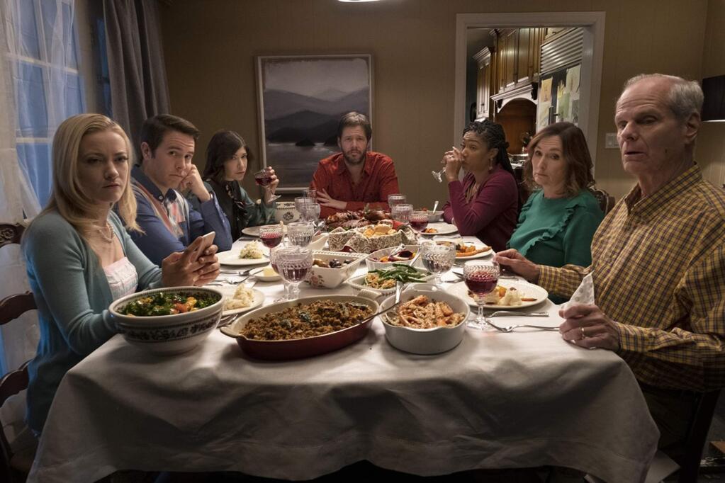 Ike Barinholtz, center, and Tiffany Haddish, third frim right, and Carrie Brownstone, third from left, in the political satire 'The Oath,' about relatives who gather for the holiday after citizens are asked to sign a loyalty oath to the president. (Roadside Attractions)