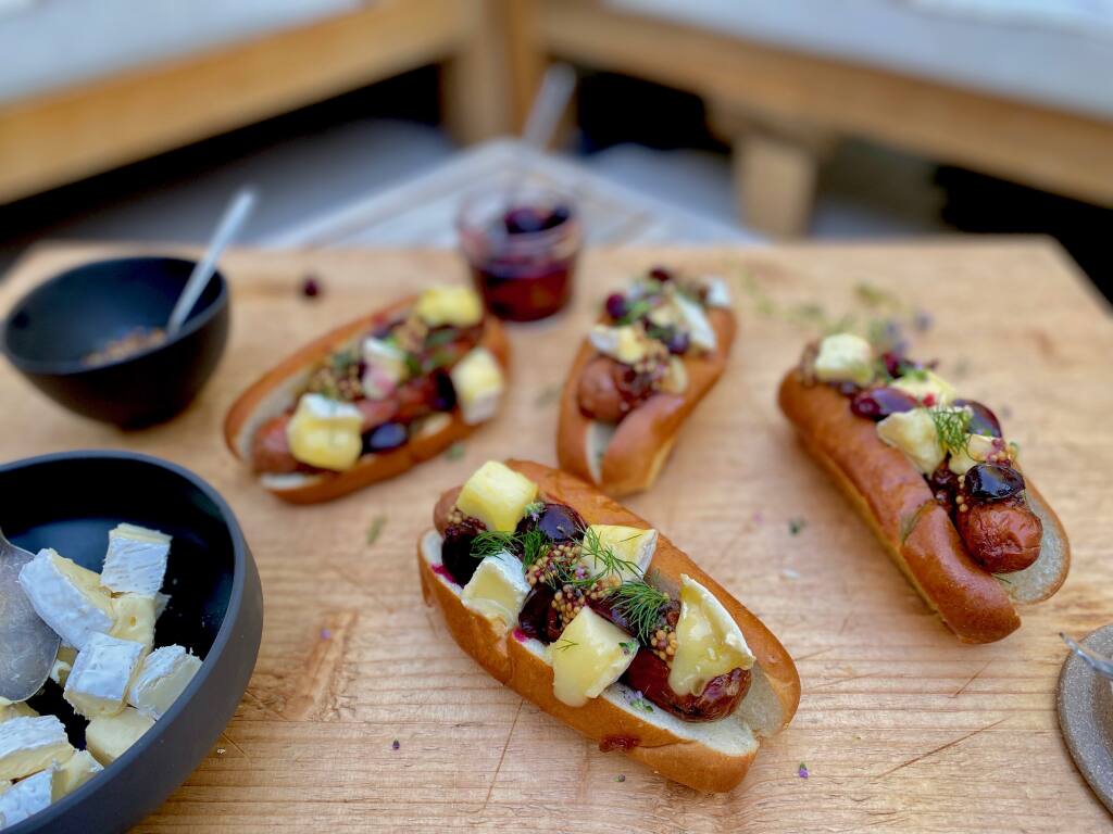Try a fun summer cheese dog:  Frankfurter with Cowgirl Creamery’s Mt. Tam, Bacon Jam, Pickled Cherries, Mustards and Herbs on a Brioche Bun. (Cowgirl Creamery)
