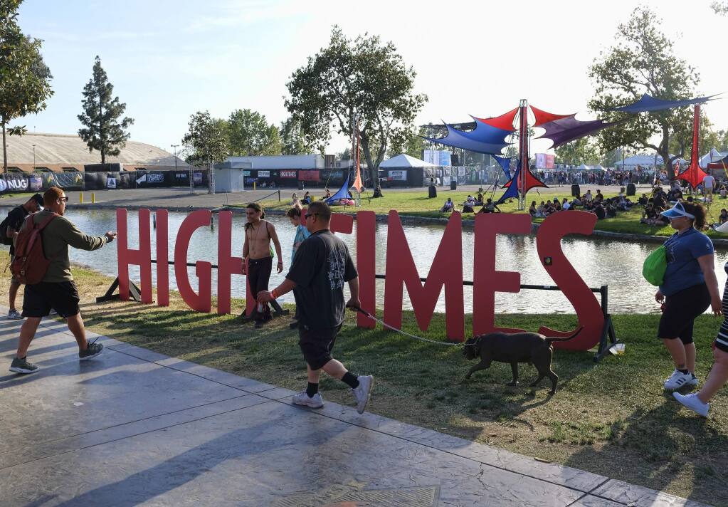 FILE - In this Sunday, April 23, 2017, file photo, visitors arrive at the fairgrounds to attend the High Times Cannabis Cup in San Bernardino, Calif. The owner of High Times is going to start selling marijuana after championing its use in the pages of its magazine for nearly half a century. Hightimes Holding Corp. said Tuesday, April 28, 2020 is acquiring 13 dispensaries from Harvest Health and Recreation, one of the largest multi-state producers and sellers of cannabis in the U.S. (AP Photo/Richard Vogel, File)
