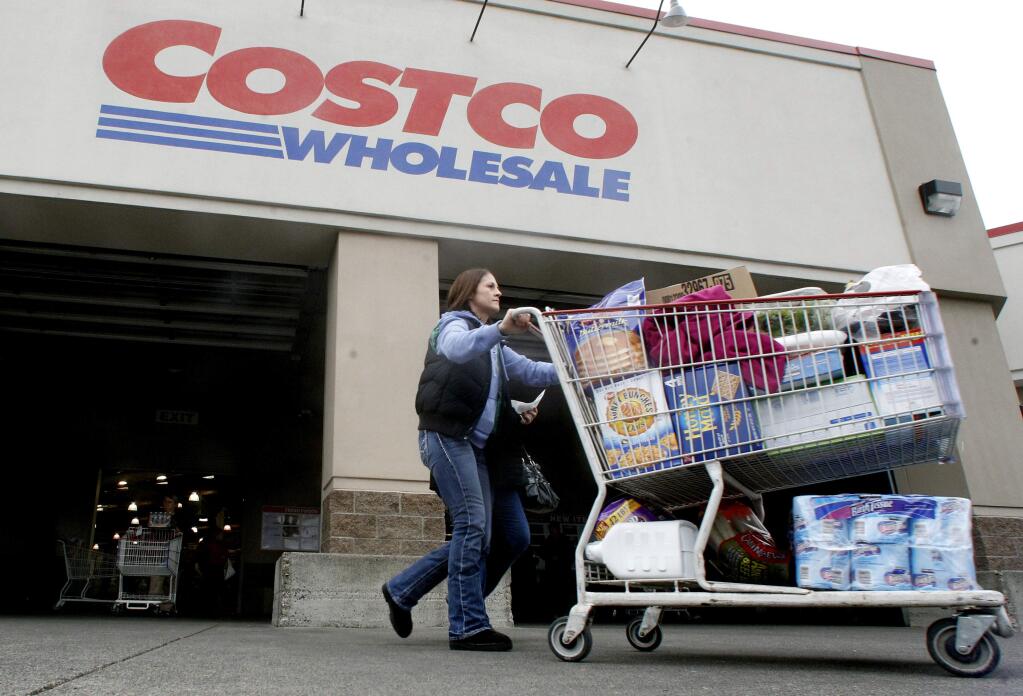 FILE - In this Dec. 7, 2011 file photo, a shopper leaves a Costco store in Portland, Ore. (AP Photo/Rick Bowmer, File)