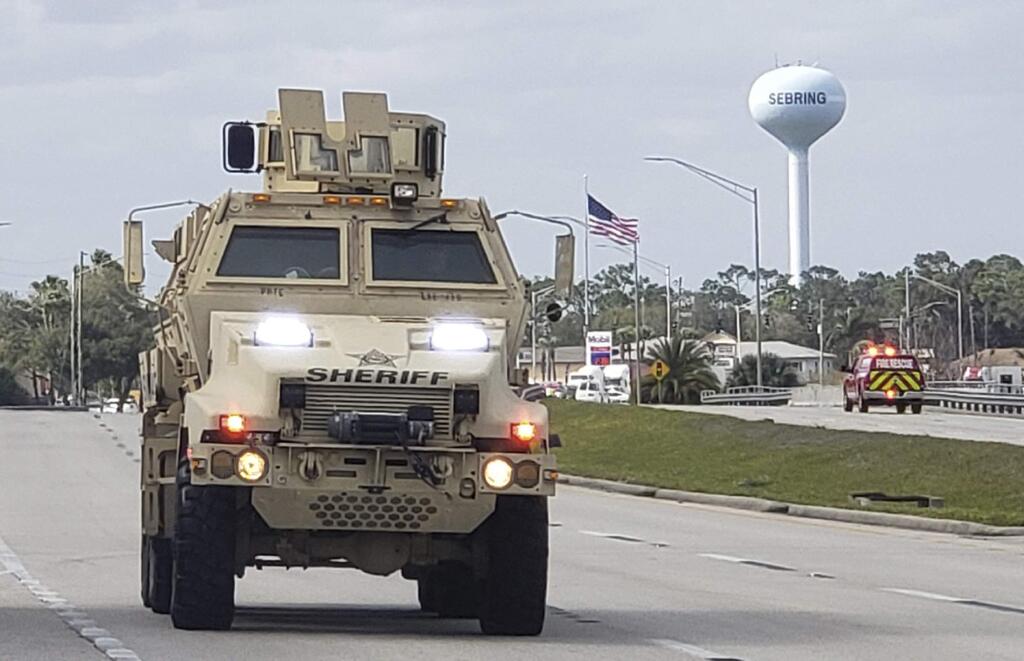 A sheriff's department armored vehicle arrives at a SunTrust Bank branch, Wednesday, Jan. 23, 2019, in Sebring, Fla. Authorities say they've arrested a man who fired shots inside the Florida bank. (The News Sun via AP)