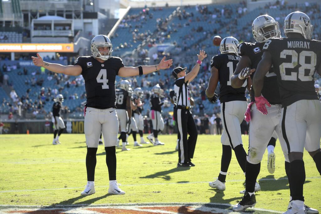 Oakland Raiders quarterback Derek Carr (4) celebrates after running back Latavius Murray (28) rushed for a touchdown during the second half against the Jacksonville Jaguars in Jacksonville, Fla., Sunday, Oct. 23, 2016. The Raiders won 33-16. (AP Photo/Phelan M. Ebenhack)