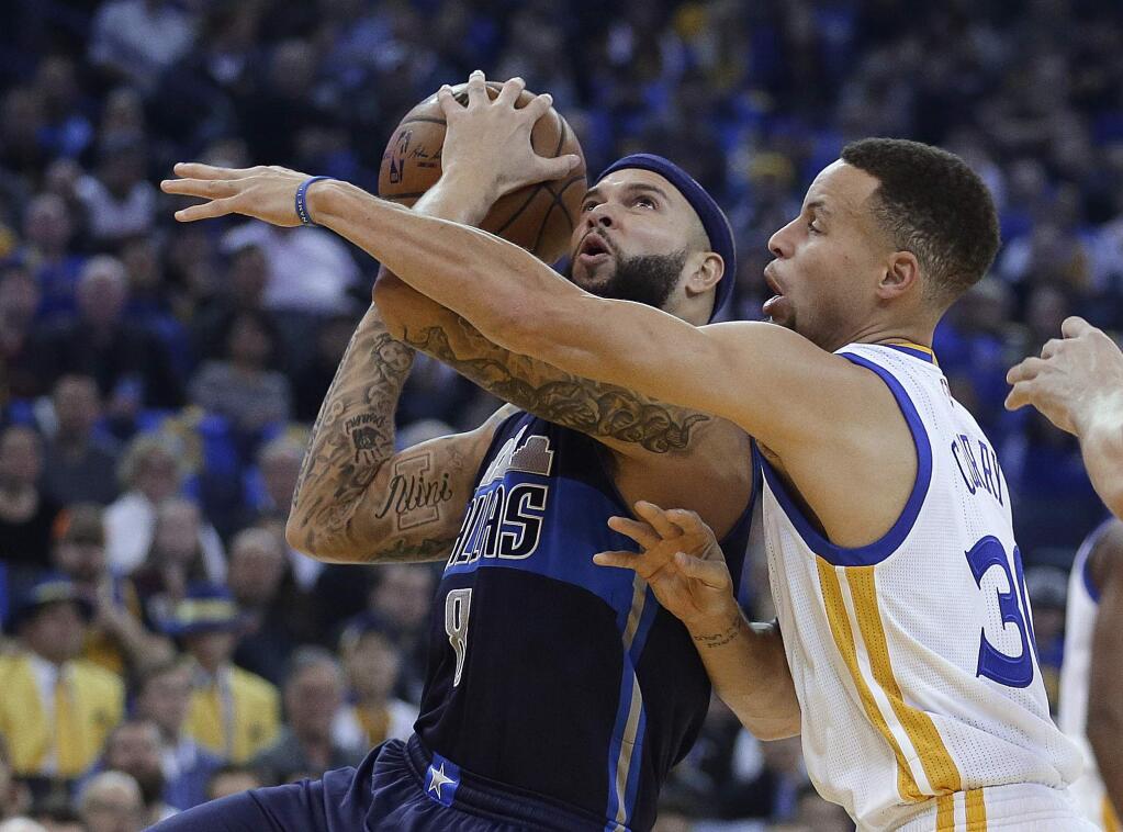 Dallas Maverick's Deron Williams, left, looks to shoot against Golden State Warriors' Stephen Curry (30) during the first half of an NBA basketball game Wednesday, Jan. 27, 2016, in Oakland, Calif. (AP Photo/Ben Margot)