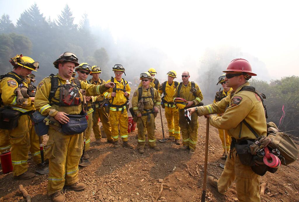 The Toulomne-Calaveras Cal Fire Unit discuss their plans to set a blackline, from the holding line to the oncoming fire, in order to create a buffer at the northeast corner of the Lodge Complex Fire, north of Laytonville on Monday, Aug. 11, 2014. (Christopher Chung / The Press Democrat)