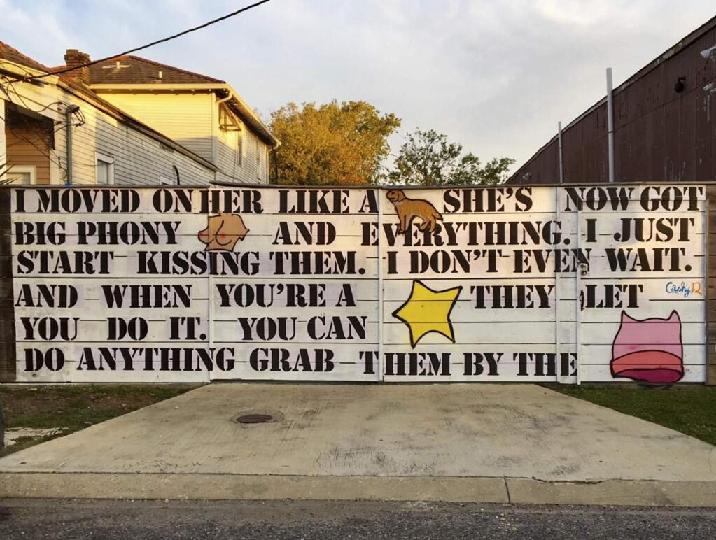 This Nov. 5, 2017 photo provided by Neal Morris shows a mural on his property in New Orleans, La. On Tuesday, March 13, 2018, the American Civil Liberties Union went to court for Morris who says he's been ordered to remove the large mural that features infamous Donald Trump quotes from a 2005 'Access Hollywood' recording. A federal court lawsuit says Morris was ordered by the city to remove the mural soon after it was painted in November. (Neal Morris via AP)