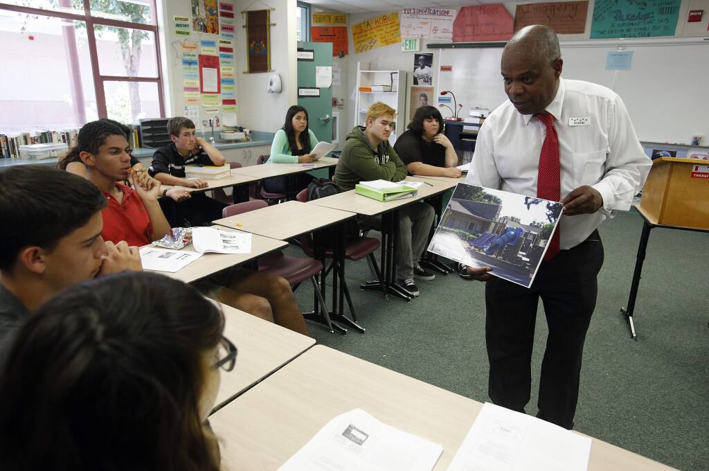 Vince Harper of Community Action Partnership shows Elsie Allen High School students photo examples prior to sending them out in their own neighborhoods to document things they like and dislike about their neighborhood, Monday, Aug. 25, 2014. (Crista Jeremiason / The Press Democrat, 2014)