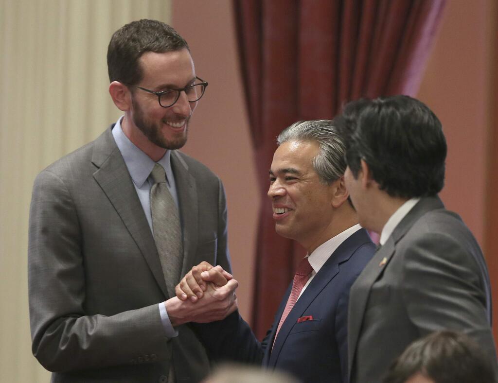 State Sen. Scott Wiener, D-San Francisco, left, receives congratulations from Assemblyman Rob Bonta, D-Alameda, center, and Sen. Kevin de Leon, D-Los Angeles, right, after his net neutrality bill was approved by the state Senate, Friday. “This is basic consumer protections, protecting small and midsize businesses, protecting activists and labor unions and anyone else who uses the internet,” Wiener said. (AP Photo/Rich Pedroncelli)
