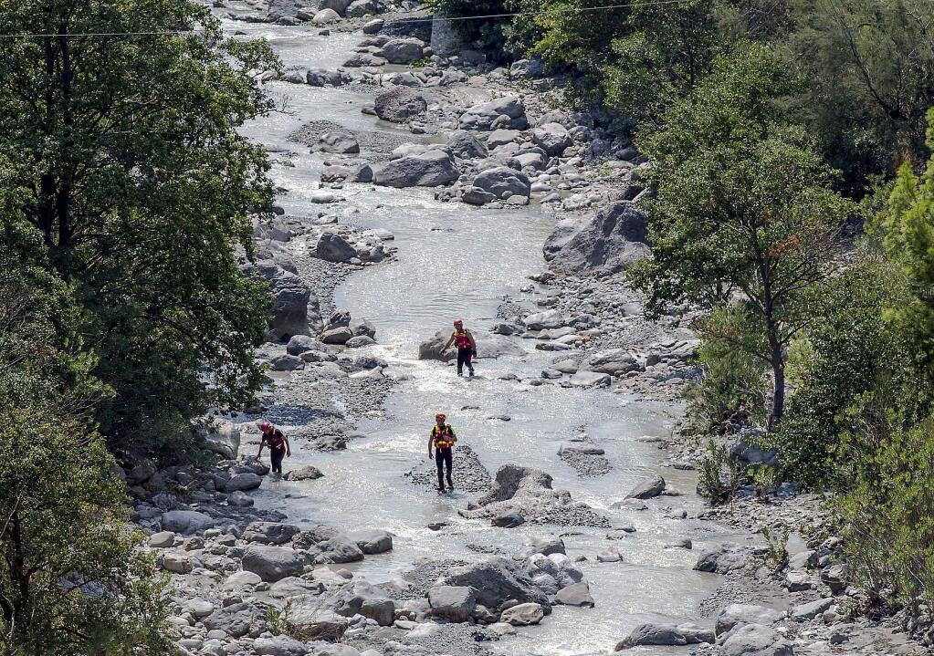 Rescuers search through the Raganello stream, Italy, Tuesday Aug. 21, 2018. Italian prosecutors have opened a criminal investigation into the deaths of at least 10 people swept away by a flash flood as they hiked through a narrow gorge in the southern region of Calabria. Italy's civil protection agency said at least three people were missing, although the number could be higher since guides were not mandatory inside the Raganello Gorge. (Francesco Arena/ANSA via AP)