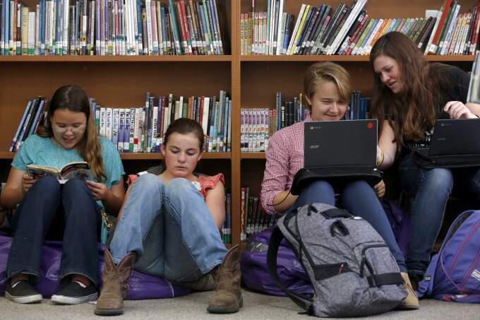 From left, Mcayla Duren, 14, Sarah Lindsay, 14, Juliana Parker, 13, and Catherine Slight, 13, spend their lunch period in the library at Petaluma Junior High School on Monday, Oct. 6, 2014. (BETH SCHLANKER/ PD)
