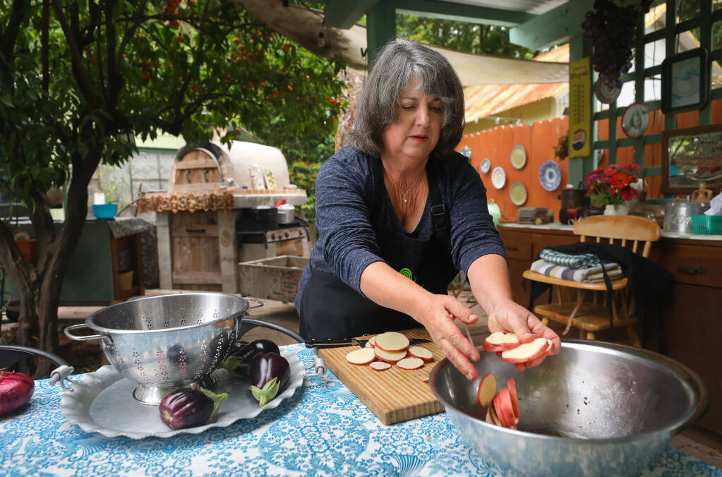 Marie Giacalone, a member of Slow Food Sonoma County North, slices Bodega Red heirloom potatoes, grown in her garden, while preparing her Bodega Red and Eggplant Al Forno dish in Cloverdale. (Christopher Chung/ The Press Democrat)
