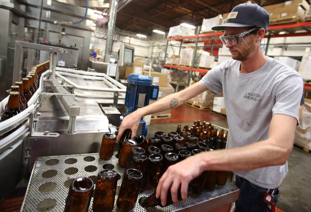 George Gatton, does quality control on the bottling line at the Lagunitas Brewing Co., production facility in Petaluma, Friday, October 24, 2014. (Crista Jeremiason / The Press Democrat)