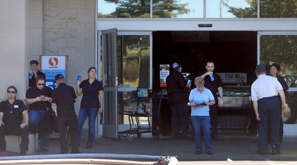 Safeway employees mill around the entrance to the Rohnert Park  Safeway store, Monday, July 15, 2019, after smoke from a fire forced them to evacuate,    (Kent Porter /  The Press Democrat) 2019