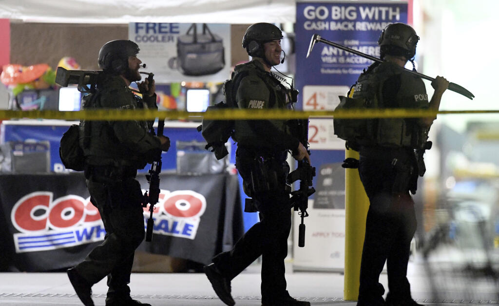 FILE - Heavily armed police officers leave the Corona, Calif., Costco store following the fatal shooting of Kenneth French by an off-duty Los Angeles Police officer, June 14, 2019. A judge says a former Los Angeles police officer who was off duty when he fatally shot French during a confrontation at the Costco store must stand trial on manslaughter and other charges. (Will Lester/The Orange County Register/SCNG via AP, File)