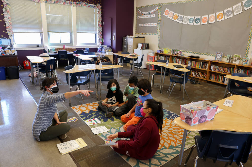 Fourth-grade teacher Sierra Bradley works with four of her seven students that came to school at Santa Rosa Charter School for the Arts on Tuesday, Jan. 11, 2022. Bradley usually has 20 students in her class. (Christopher Chung/ The Press Democrat)