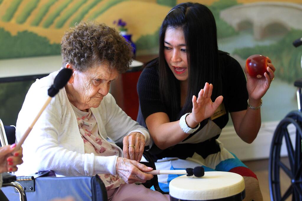 Activities director Celeste Lim sings and drums with Beverly Cundiff during a drumming circle at Park View Post Acute skilled nursing home in Santa Rosa. (JOHN BURGESS / The Press Democrat)