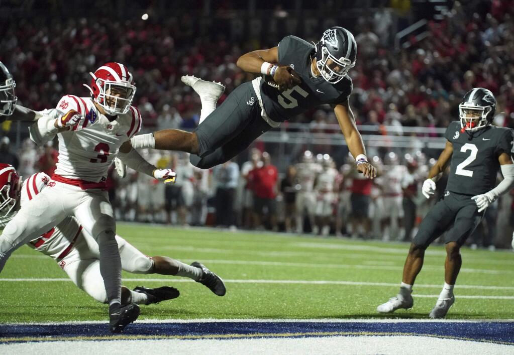 FILE - In this Friday, Oct. 25, 2019 file photo, Despite the acrobatic jump by St. John Bosco quarterback DJ Uiagalelei (5) into the end zone, it was called back due to a penalty against Mater Dei in Bellflower, Calif. Only Texas and Florida produce more major college football players than California, but across the state overall participation in the sport at the high school level is on the decline. The percentage of players competing at the highest level of college football who are from California has dropped, too. (Scott Varley/The Orange County Register via AP, File)