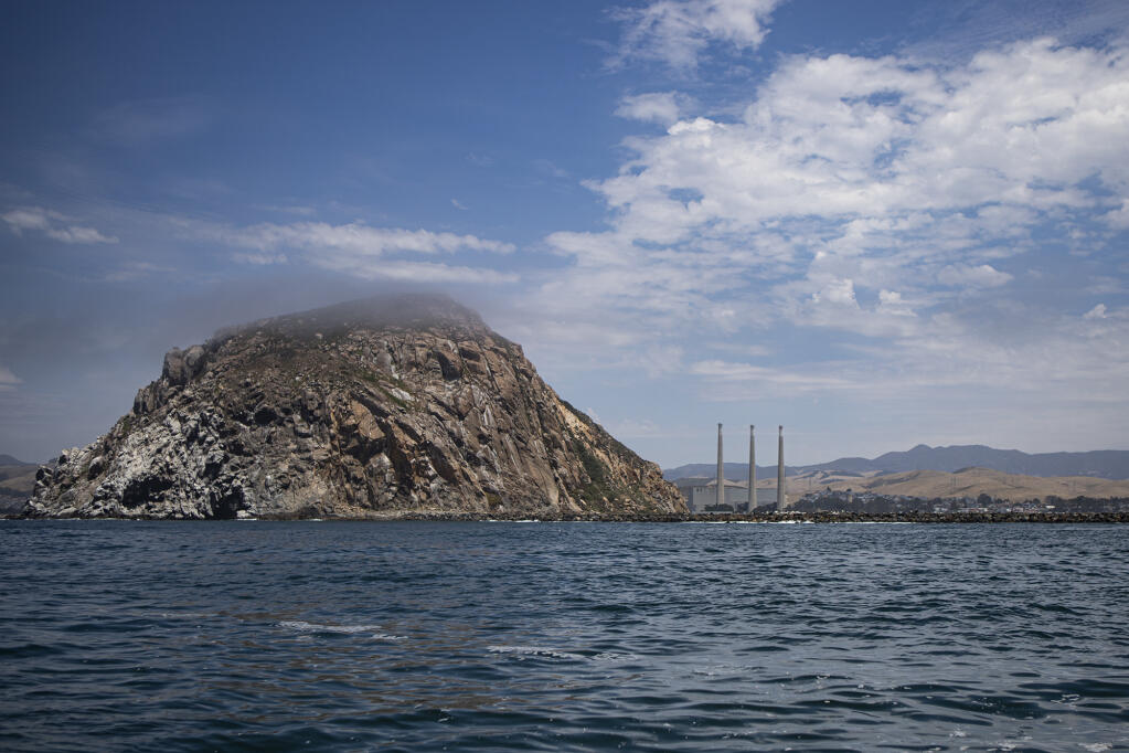 Afternoon fog slowly covers Morro Rock, a major landmark in Morro Bay. The federal government has leased 376 square miles of oceans waters off Morro Bay for floating wind farms. Photo by Larry Valenzuela, CalMatters/CatchLight Local