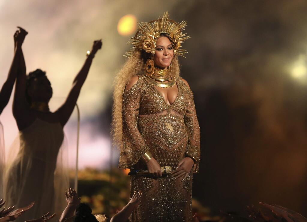 FILE - This Feb. 12, 2017, file photo, shows Beyonce performing at the 59th annual Grammy Awards in Los Angeles. Beyonce shared photos of her growing baby bump on her website Monday, March 6, 2017. She and husband Jay Z are expecting twins. (Photo by Matt Sayles/Invision/AP, File)
