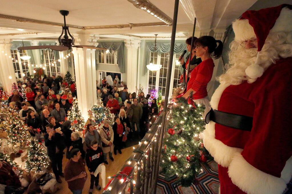 Santa Claus stands with Melissa Becker and Krista Gawronski of the Fabulous Women of Sonoma County as they announce the recipients of the evenings charity proceeds during the Festival of Trees at Hotel Petaluma in Petaluma, California on Friday, December 1, 2017. (Alvin Jornada / The Press Democrat)