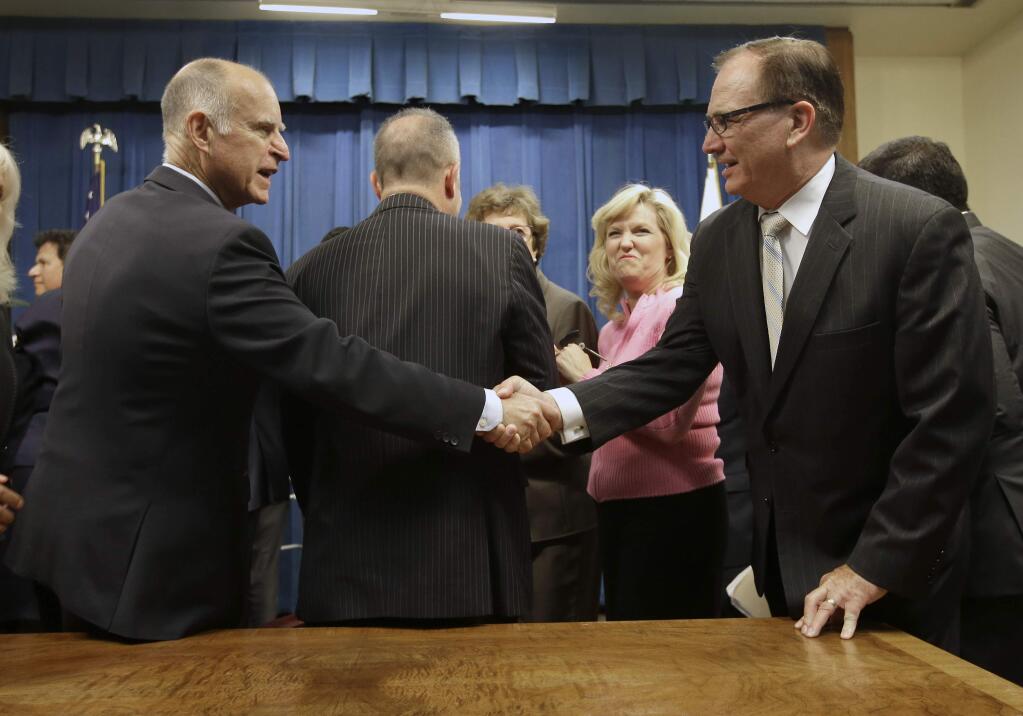 Gov. Jerry Brown, left, shakes hands with Senate Minority Leader Bob Huff, R-Diamond Bar, after Brown signed a measure to place a $7.5 billion water plan on the November ballot, Wednesday, Aug. 13, 2014, in Sacramento. The measure replaces an existing water bond that was approved by a previous Legislature but was widely considered to costly and unlikely to be approved by voters. The water plan was approved by lawmakers earlier in the day after weeks of negotiations between Brown and legislative leaders. (AP Photo/Rich Pedroncelli)
