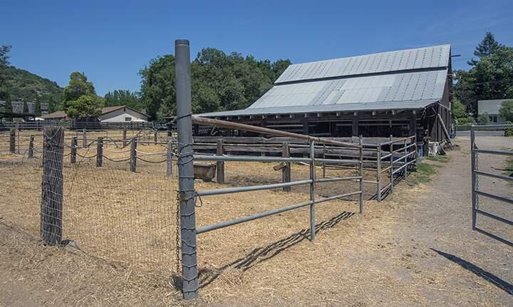 The main barn with attached paddocks at the working farm on East Spain Street and Second St. East, best known for its Clydesdale draft horses,. The property has been sold.(Photo by Robbi Pengelly/Index-Tribune)