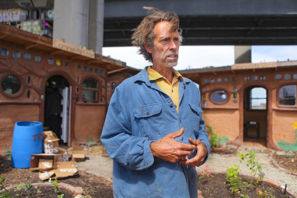 Petaluma artist Miguel Elliott talks about the “Cob on Wood” project, which sits under Interstate 880 in Oakland, on Monday, June 21, 2021. Elliott built the unsanctioned community gathering space, and he envisions similar projects in Sonoma County, where the appetite for tiny home villages as a solution to homelessness is growing. (CRISSY PASCUAL/ARGUS-COURIER STAFF)