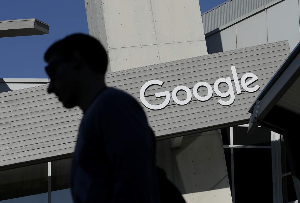FILE - In this Nov. 12, 2015, file photo, a man walks past a building on the Google campus in Mountain View, Calif. Google is enabling users of its digital mapping service to allow their movements to be tracked by friends and family in the latest test of how much privacy people are willing to sacrifice in an era of rampant sharing. The location-monitoring feature will begin rolling out Wednesday, March 22, 2017, in an update to the Google Maps mobile app that's already on most of the world's smartphones. It will also be available on personal computers. (AP Photo/Jeff Chiu, File)