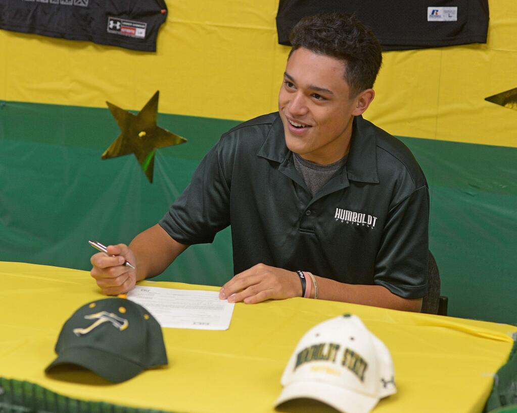 SUMNER FOWLER/FOR THE ARGUS-COURIERCasa Grande High School senior Kaleo Garrigan signs a Letter of Intent to accpet a football scholarship from Humboldt State University.