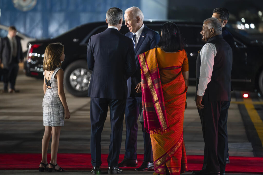President Joe Biden greets U.S. Ambassador to India Eric Garcetti and his daughter Maya, as Vijay Kumar Singh, Minister of State for Road Transport and Highways & Minister of State for Civil Aviation, and Vani Sarraju Rao, Joint Secretary in the Ministry of External Affairs, center, watch, as he arrives at Indira Gandhi International Airport to attend the G20 summit, Friday, Sept. 8, 2023, in New Delhi. (AP Photo/Evan Vucci)