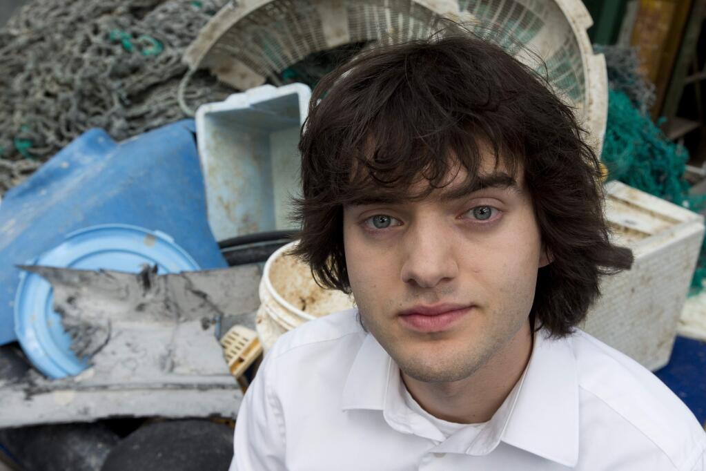 FILE - In this May 11, 2017, file photo, Dutch innovator Boyan Slat poses for a portrait next to a pile of plastic garbage prior to a press conference in Utrecht, Netherlands. (AP Photo/Peter Dejong, File)