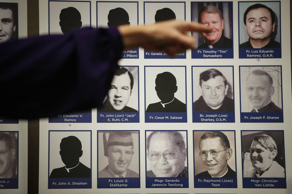 A sexual abuse victim points to the photos of Catholic priests accused of sexual misconduct by victims during a news conference in Orange on Dec. 6, 2018. Photo by Jae C. Hong, AP Photo