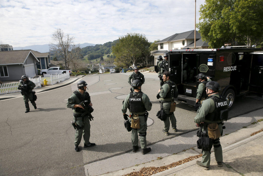 Members of the San Rafael-Novato SWAT team search a neighborhood  in northern Novato for Petaluma home invasion suspects on Monday, March 12, 2018 in Novato, California . (BETH SCHLANKER/The Press Democrat)