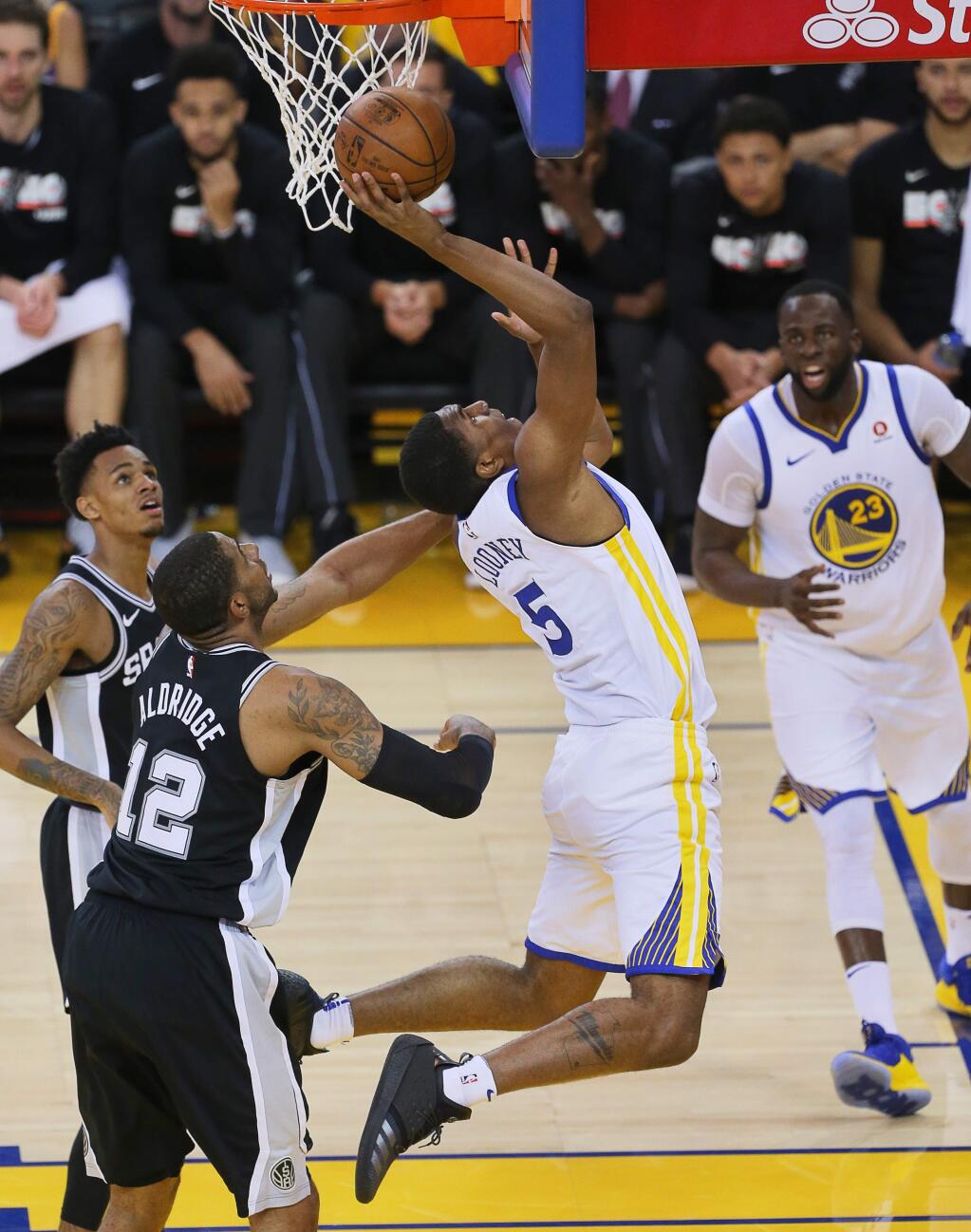 Golden State Warriors forward Kevon Looney gets the shot after the foul by San Antonio Spurs center LaMarcus Aldridge, during their game in Oakland on Tuesday, April 24, 2018. (Christopher Chung/ The Press Democrat)