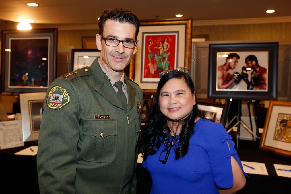 Sonoma County assistant sheriff Clint Shubel with event organizer Ruby Wight during Rise Up North Bay, a dinner and dance to benefit fire victims through the Redwood Empire Food Bank and Community Action Partnership, in Rohnert Park, California on Saturday, December 16, 2017. (Alvin Jornada / The Press Democrat)