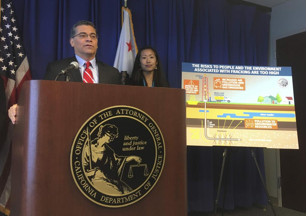 California Attorney General Xavier Becerra, left, with Deputy Attorney General Yvonne Chi, discusses the state's lawsuit challenging the Trump administration over the U.S. Bureau of Land Management's decision to open more than 1 million acres of public land to oil and gas drilling in the middle of the state, on Friday, Jan. 17, 2020, in Sacramento, Calif. Becerra said the federal government could allow more use of the controversial extraction method known as fracking without properly considering the consequences. (AP Photo/Don Thompson)