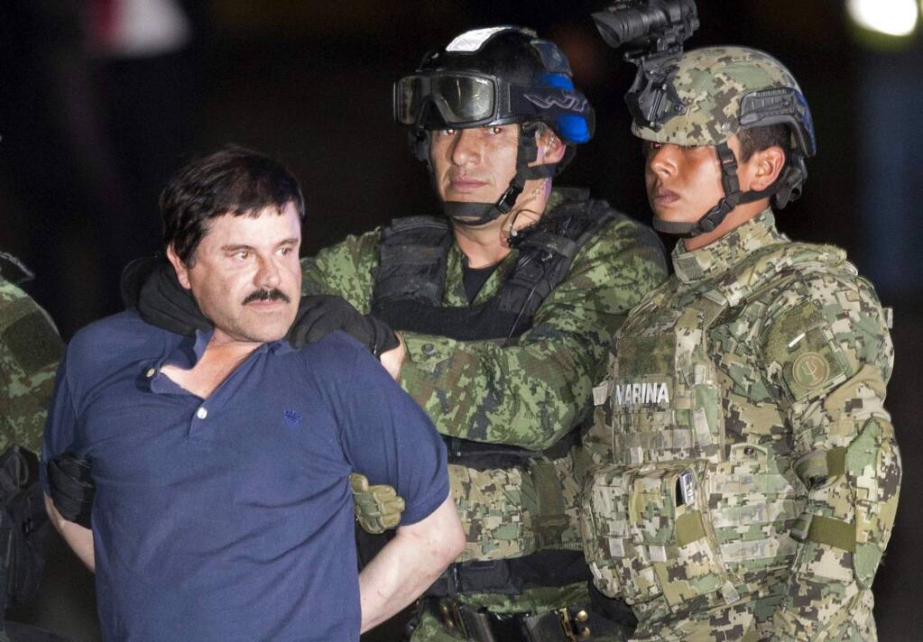 Joaquin 'El Chapo' Guzman is made to face the press as he's escorted to a helicopter in handcuffs by soldiers and marines in Mexico City. (EDUARDO VERDUGO / Associated Press)