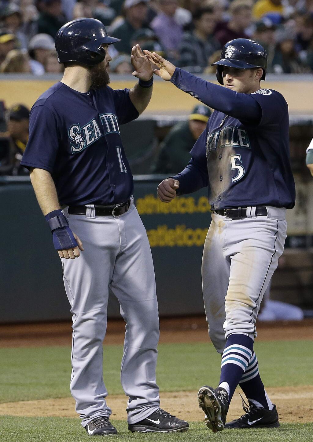 Seattle Mariners' Brad Miller, right, celebrates after hitting a two-run home run that scored Dustin Ackley, left, during the eighth inning of a baseball game against the Oakland Athletics in Oakland, Calif., Friday, July 3, 2015. (AP Photo/Jeff Chiu)