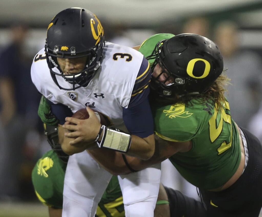 Cal quarterback Ross Bowers, left, is sacked by Oregon's Henry Mondeaux during the third quarter Saturday, Sept. 30, 2017, in Eugene, Oregon. (AP Photo/Chris Pietsch)