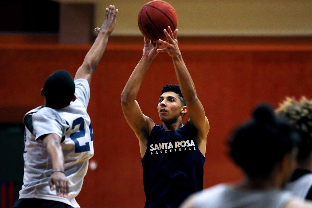 SRJC's Ryan Perez sinks a three-pointer past Nick Cole during practice at Haehl Pavilion in Santa Rosa on Tuesday, March 5, 2019. (Alvin Jornada / The Press Democrat)