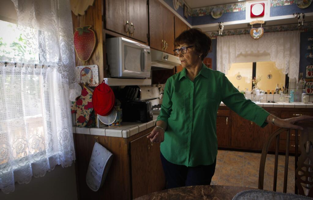 Petaluma, CA, USA. Monday, July 24, 2017._ Mary Moynihan has lived in her Petaluma home for over 50 years with her husband, Jerry. But an air bnb rental next door has been causing them trouble since 2012. Mary can see the property and its occupants through the lace curtains of her kitchen window. (CRISSY PASCUAL/ARGUS-COURIER STAFF)
