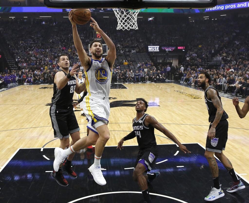 Golden State Warriors guard Klay Thompson, second from left, goes to the basket against Sacramento Kings' Nemanja Bjelica, left, Buddy Hield, third from left and Willie Cauley-Stein, right, during the first half of an NBA basketball game Friday, Dec. 14, 2018, in Sacramento, Calif. (AP Photo/Rich Pedroncelli)