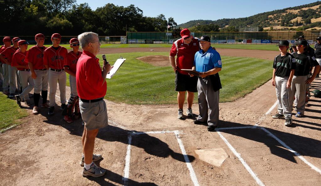 Longtime umpire Ron Nagy, center, in blue, is presented with a commendation letter from the CEO of Little League Baseball by California Little League District 35 administrator Don Goodman, left, and District 35 umpire-in-chief Rod Lund before a game between the Petaluma National and Vacaville Central at Rincon Valley Little League Park in Santa Rosa on Wednesday, July 20, 2016. (Alvin Jornada / The Press Democrat)