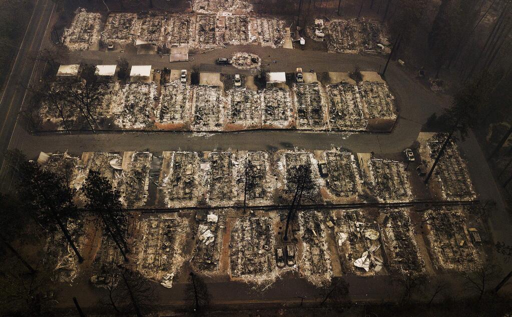 FILE - This Nov. 15, 2018, aerial file photo shows the remains of residences leveled by the Camp wildfire in Paradise, Calif. The California Fair Access to Insurance Requirements Plan is a state-mandated insurance pool required to sell insurance policies to people who can't buy coverage through no fault of their own. FAIR Plan policies are often limited to fire damage. Homeowners must purchase an additional policy to cover other hazards. Last month, state Insurance Commissioner Ricardo Lara ordered the FAIR Plan to begin selling comprehensive plans next year, an order aimed at helping people who have lost their coverage because of the growing threat of wildfires. Friday, Dec. 13, 2019, the California FAIR Plan Association sued Lara, arguing his order was illegal because state law only requires the plan to sell basic property insurance. (AP Photo/Noah Berger, File)