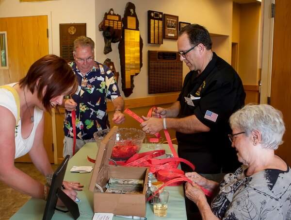 Deirdre Wood and Frank Stranzo purchase raffle tickets from Paul Barbieri and Pam Ish during the Mom's Sunday Supper, a fundraiser for 7 year old cancer patient Chanel Talent at the Elk's Club Lodge in Petaluma on Sunday, August 30, 2015. (JOHN O'HARA/FOR THE ARGUS-COURIER)